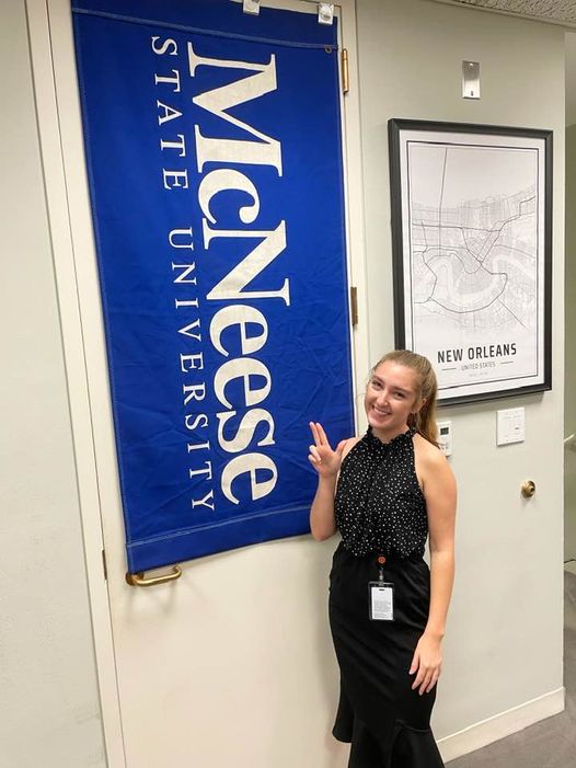 Allison stands with a McNeese banner at Sen. Cassidy's office.