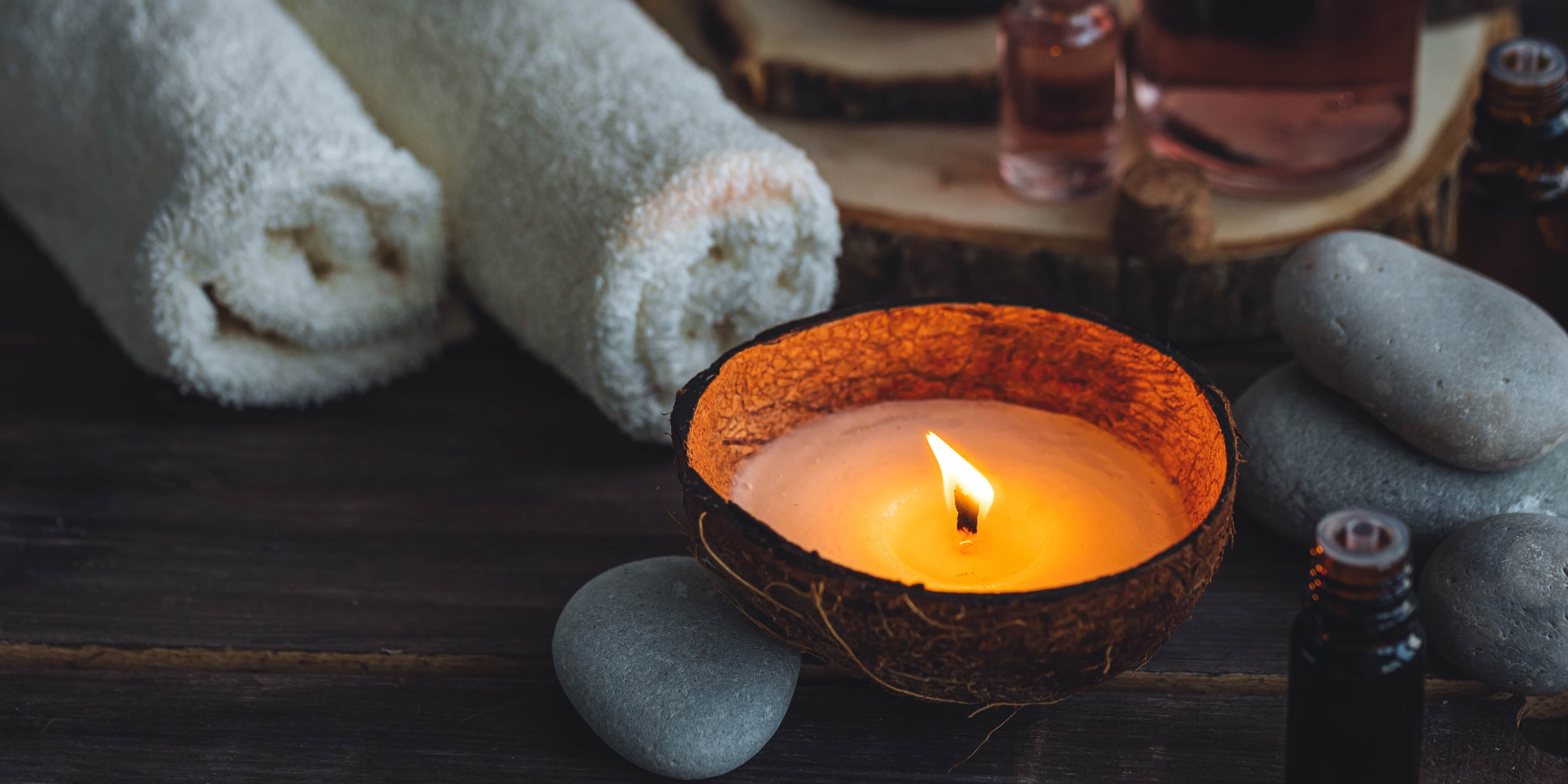 Concept of natural essential organic oils, Bali spa, beauty treatment, relax time. Atmosphere of relaxation, pleasure. Candles, towels, dark wooden background. Alternative oriental medicine