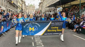 The McNeese Band and Cowgirl Kickers walk the streets of London in the parade.