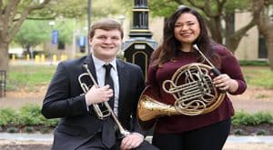 Jacob Bridges and Roxie Jo Davis in front of the post clock with their instuments