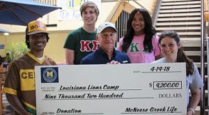 Koven Love, Austin Pottorff and Hailey Goodwin of McNeese present a check to Raymond Cecil of Louisiana Lions Camp.