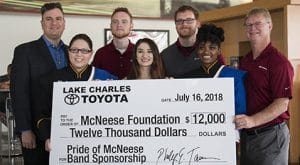 Eric, Corey and Phillip Tarver of Lake Charles Toyota present a check to Dr. Jay Jacobs of McNeese with three band members