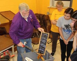 Local beekeepers show McNeese State University agricultural sciences students how to harvest the honey from the bee hives as part of the process of commercial honey production. 