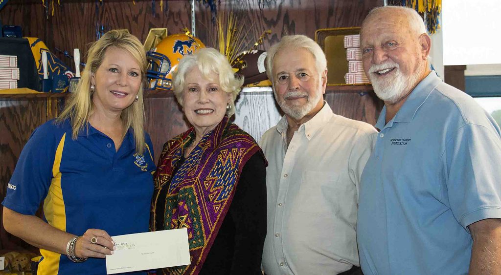 Angela Queenan and Richard Reid of McNeese accept a check from Anita and Jeff Webb.