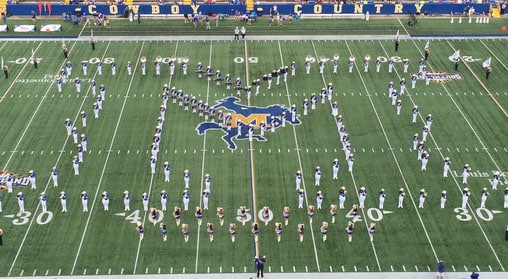 Up above view of McNeese band members in an M shape on the football field.