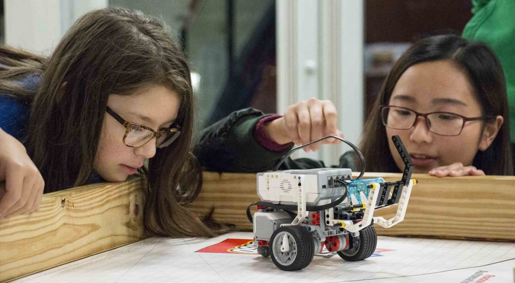 Huanrong Ouyang of McNeese helps 6th grader Ava Lankford with her robot.