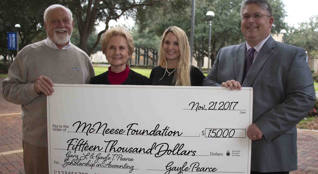 Richard Reid of McNeese accepts a check from Gayle Pearce, Stephanie Pearce Helms and Gary L Pearce Jr.