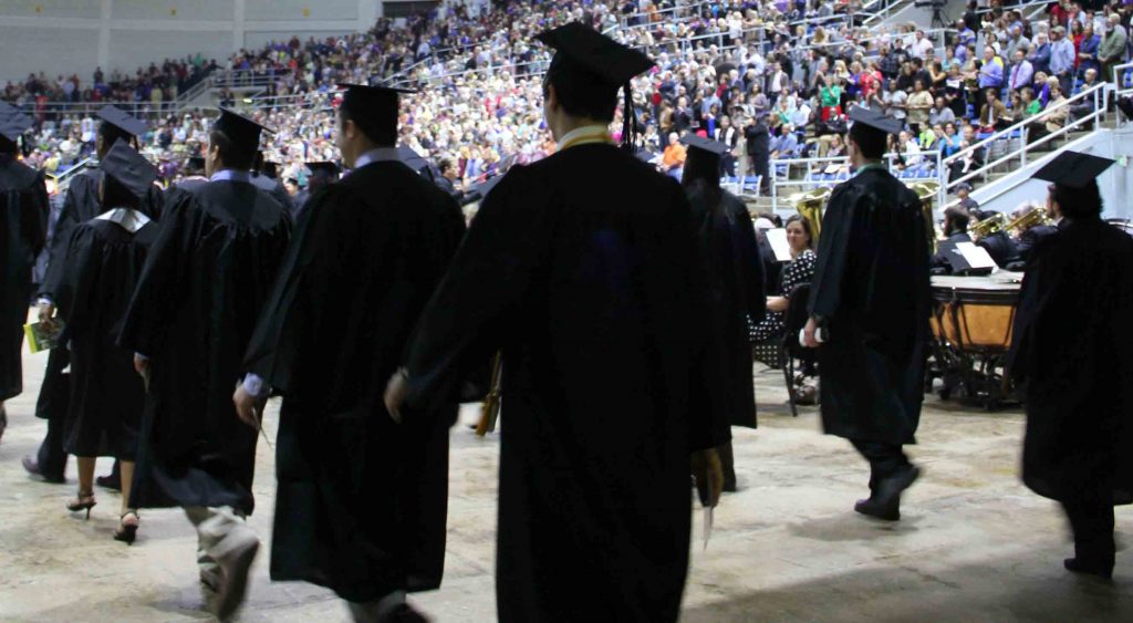 Graduates lined up and walking in to the ceremony