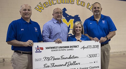 Dr. Burckel and Dr. Adrian and Dr. Soileau of McNeese accept a check from Angela Jouett of Southwest Louisiana District Senior Games.