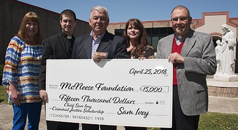 Melissa Northcutt of McNeese receives a check from the Rev. Nathan Long, Ashley Ivey-Atkins and Deacon Glenn Viau of St. Louis Catholic High School.