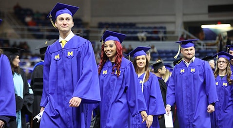 Graduation candidates walk to their seats.