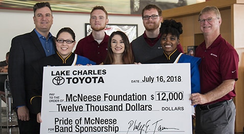 CROP.Tarver.Band.Corporate.sponsor.donation.7.18 Eric, Corey and Phillip Tarver of Lake Charles Toyota present a check to Dr. Jay Jacobs of McNeese with three band members