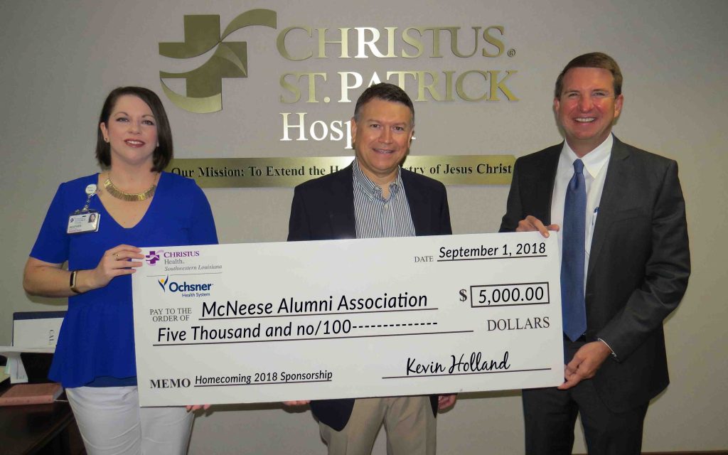 James David Cain Jr., McNeese Alumni Association president, accepts the donation from Heather Hidalgo and Kevin Holland of CHRISTUS Ocshner Health