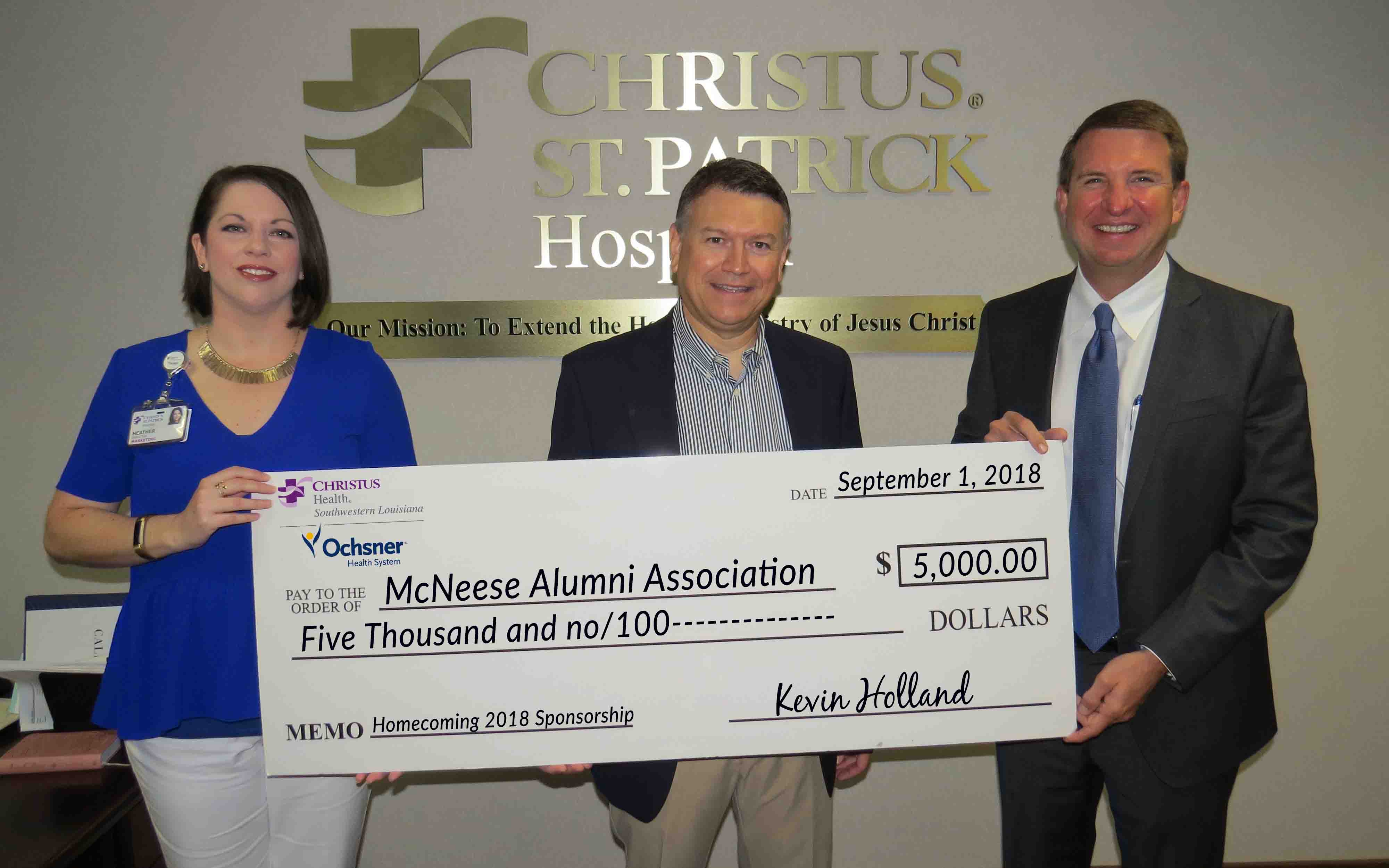 CHRISTUSOchsner.crop James David Cain Jr., McNeese Alumni Association president, accepts the donation from Heather Hidalgo and Kevin Holland of CHRISTUS Ocshner Health