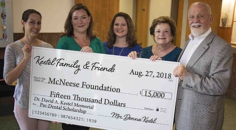 Dr. Caroline Hennigan and Richard Reid of McNeese accept a check from Amy Kestel, Stephanie Kestle Karpovs and Donna Kestel