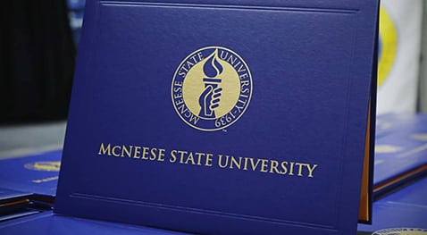 Grad cover Blue diploma cover with McNeese gold seal and university name.