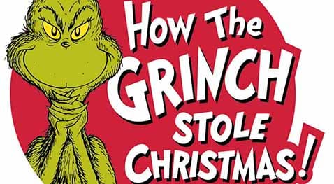 The Grinch stands smirking with the musical title to his right.