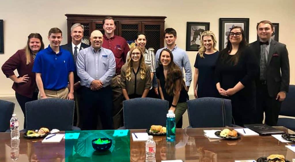 McNeese students and faculty stand with MQB partners during the Lunch and Learn.