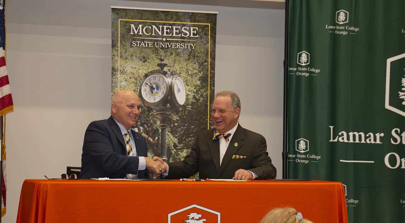 McNeese president Dr. Daryl Burckel and Lamar State College president Dr. Thomas Johnson sign the agreement.