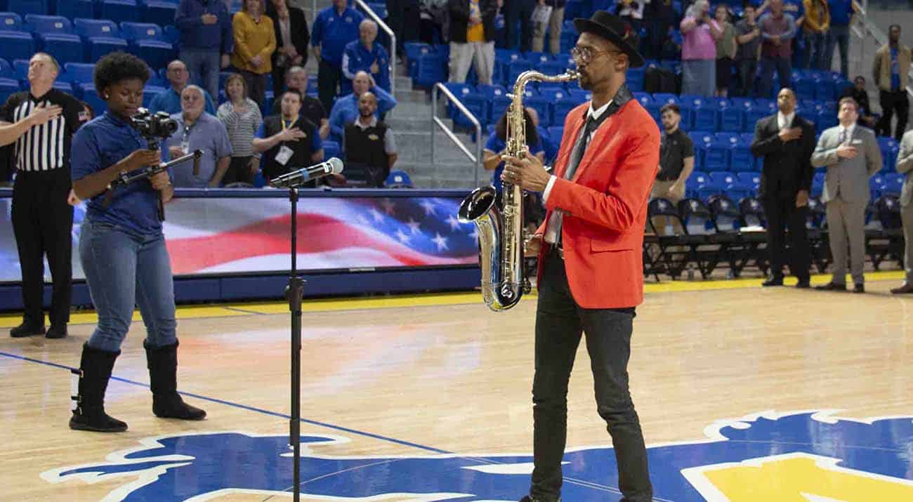 Mickey Smith plays the saxophone at a basketball game.