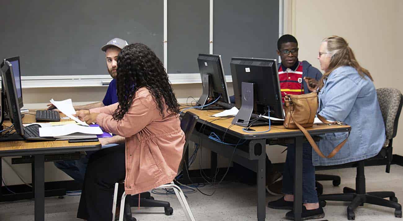 McNeese students help two VITA participants complete their tax returns.