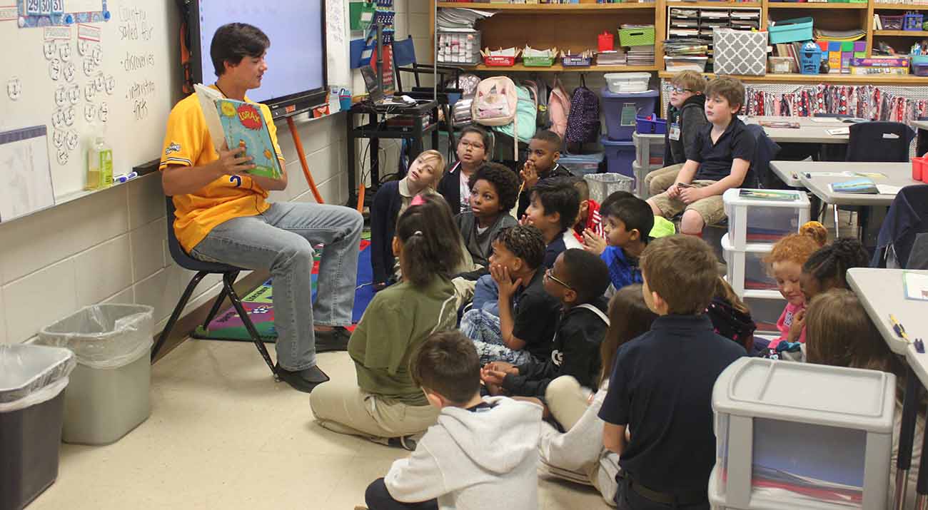 McNeese student-athlete Welles Cooley reads to Nelson Elementary students.