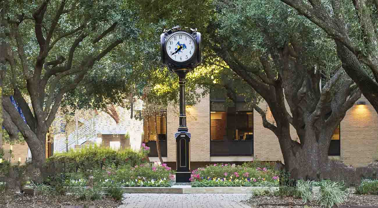 The four face clock in the Quad reads 7:39.