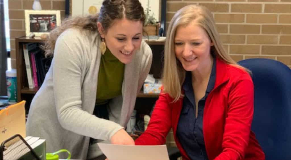 Baylie Hebert and her internship leader April Broussard review a document together.