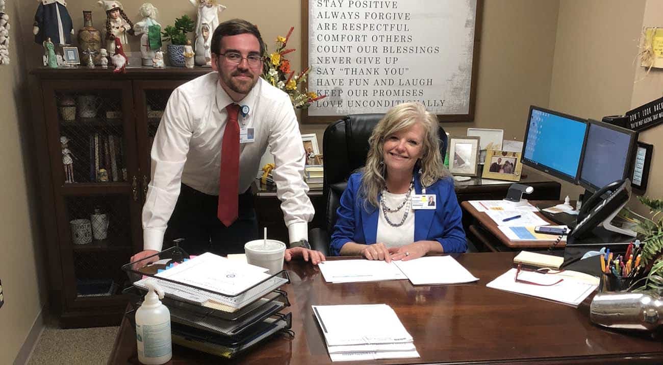 Tyler Culpepper and his internship leader smile for a photo in her office.