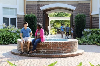 Students in housing quad by fountain