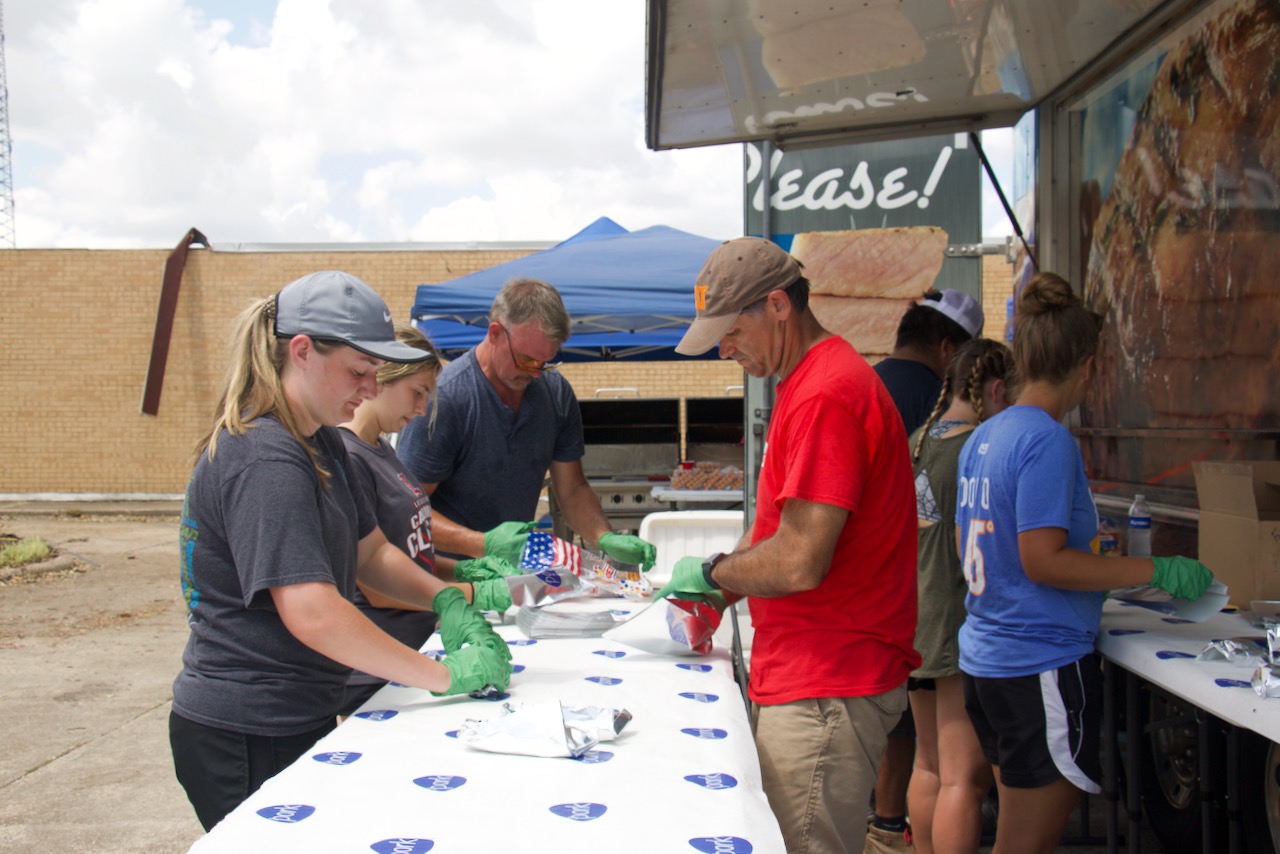 Dr. Chip LeMieux, alumni and agricutlural sciences students prepare sausage dogs