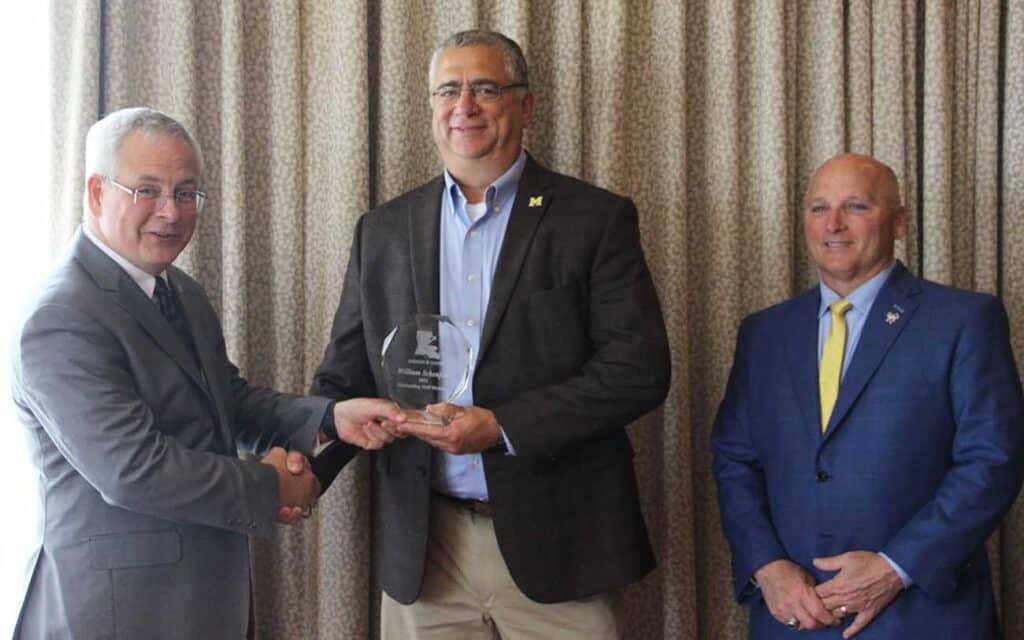 William Scheufens (center), chief of police for the McNeese Police Department, receives the Outstanding Staff member award from Dr. Jim Henderson (left), University of Louisiana System president and CEO, while Dr. Daryl Burckel (right), McNeese president, looks on.