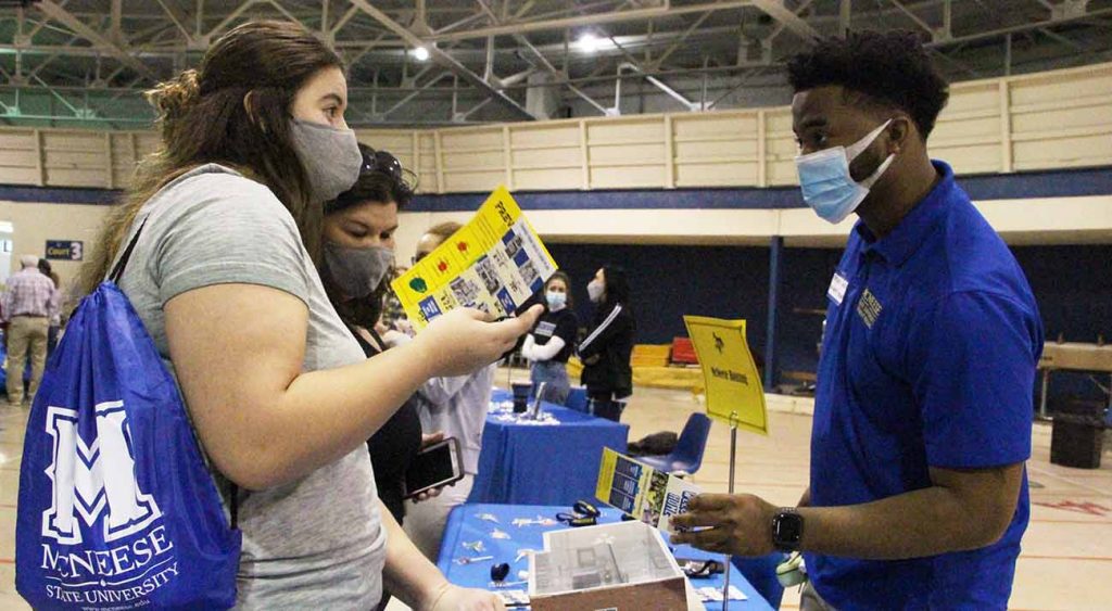 A female prospective students talks with a representative from housing.