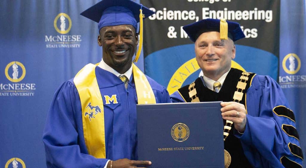 Marcellus Boykins is presented his diploma from McNeese President Dr. Daryl Burckel.