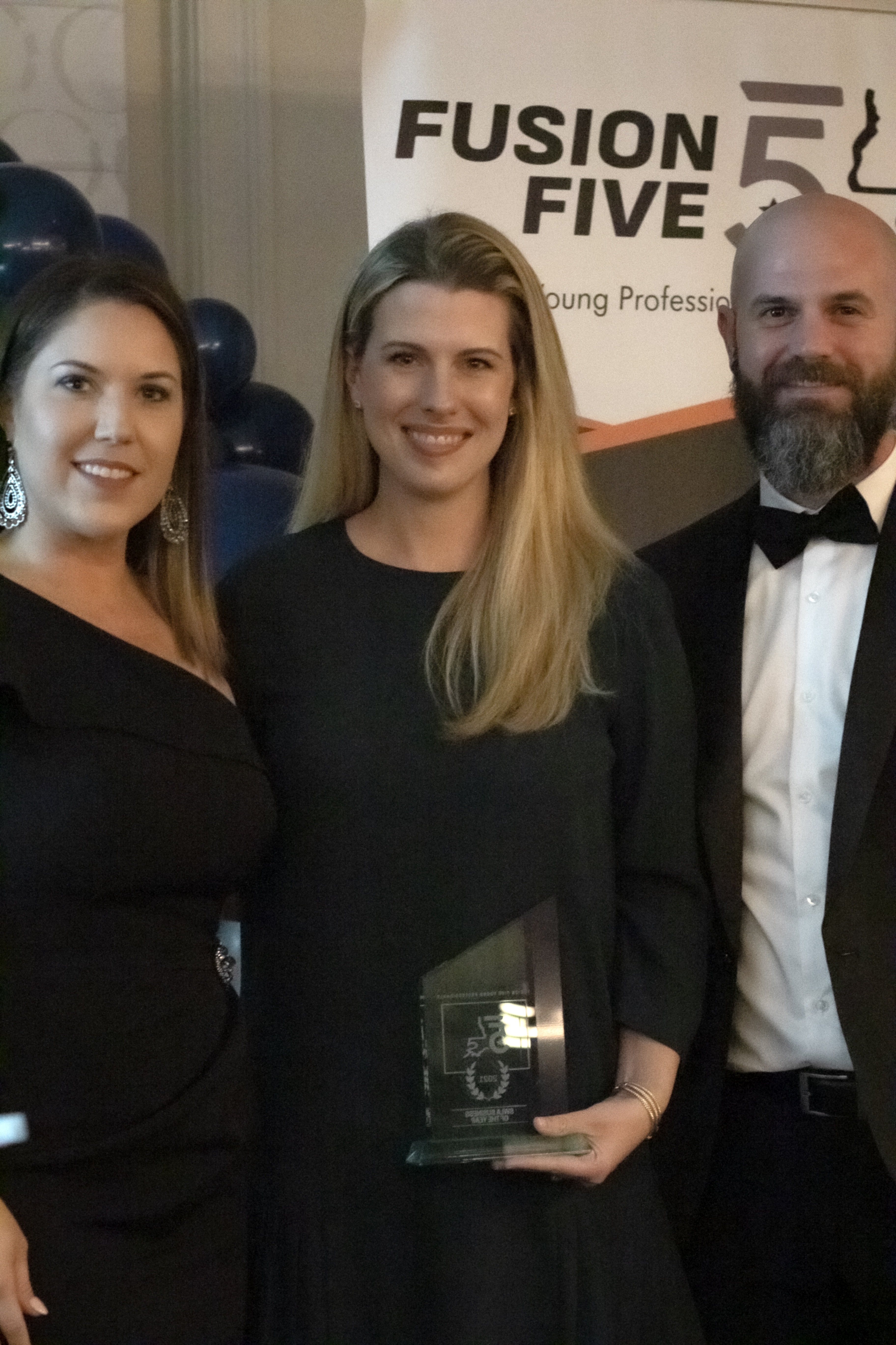 Morgan Turpin, McNeese College of Business Internship Director, center, accepts the Business of the Year Award from Fusion Five President Jenny Bono, left, and Fusion Five Board Member Josh Floyd.