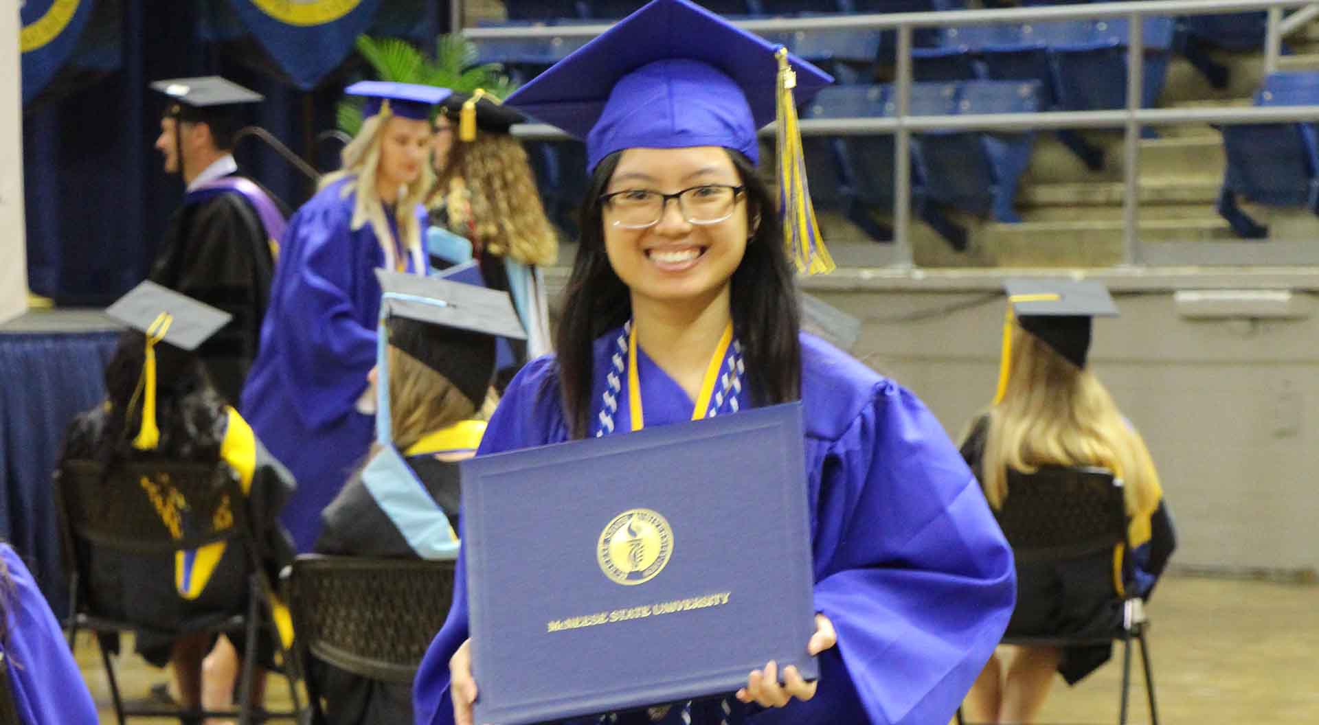 A graduate walks with their diploma cover