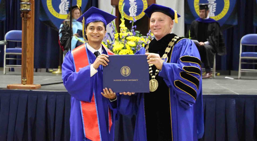 supratik regmi receives his diploma from McNeese president Dr. Daryl Burckel