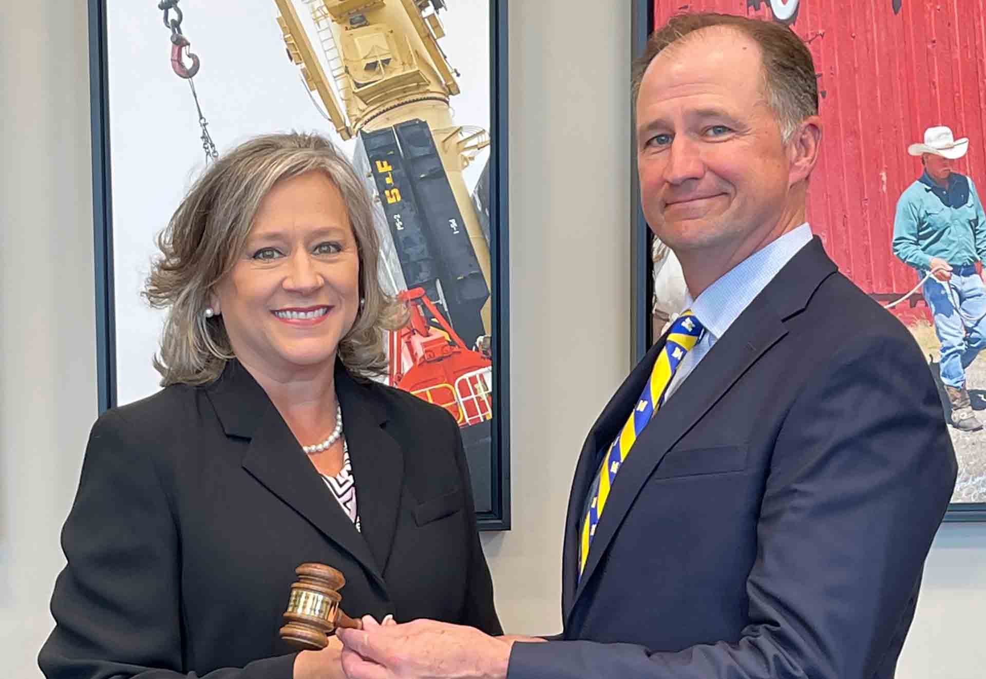 Kay Fox and Jim Giffin hold a gavel.