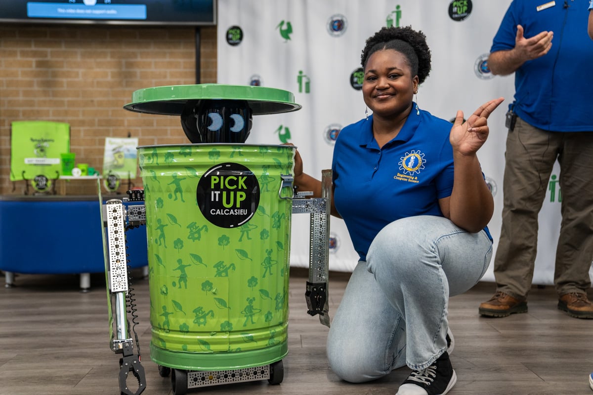McNeese studen, Chiamaka Onwude, with Trashformer, the robot a team of students built for the Calcasieu Parish Police Jury.