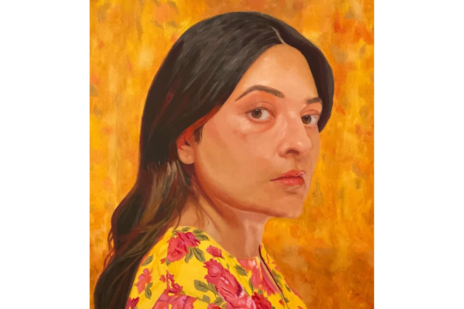 Woman with long dark hair in yellow floral blouse against vibrant orange background.
