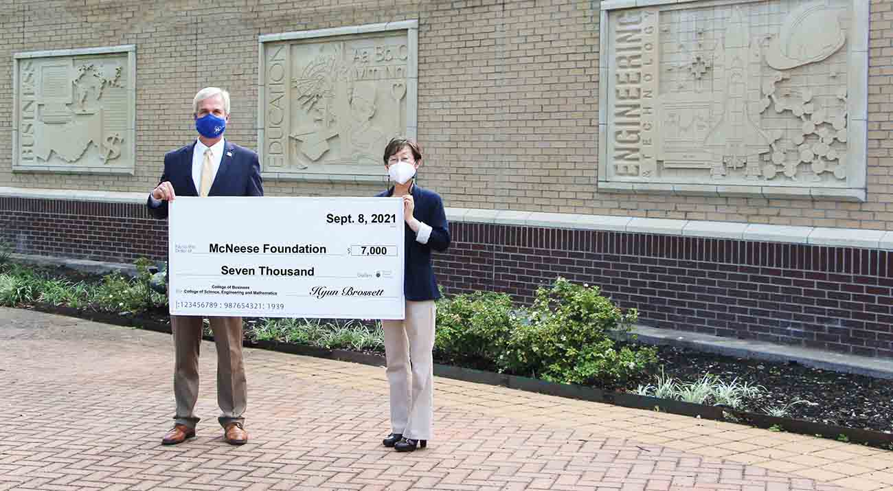 On hand for the presentation are from left: Dr. Wade Rousse, McNeese vice president for university advancement, and Hyun Brossett, Grace facility plant manager. McNeese Photo