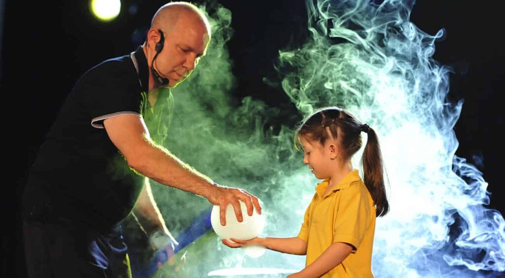 A member of the bubble bonanza fascinates a young girl with a large bubble 