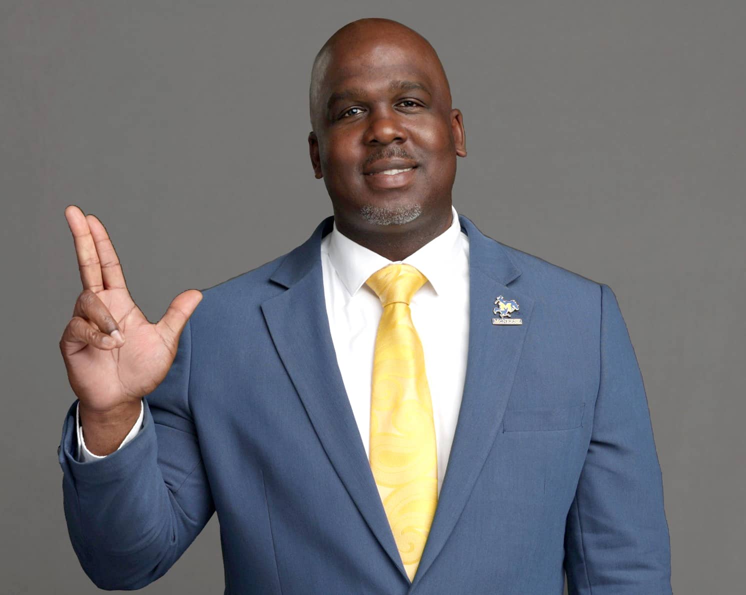 Photo of Dr. Kedrick Nicholas throwing the Geaux Pokes hand sign