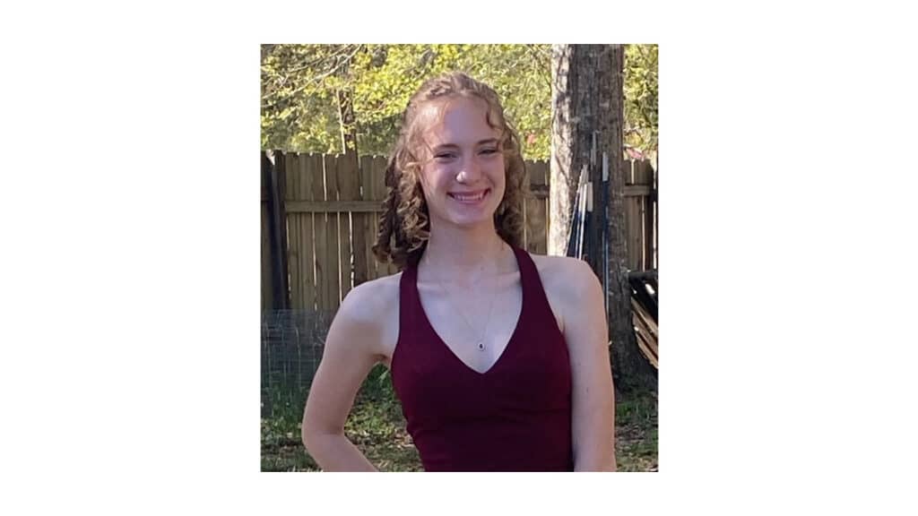 Smiling McNeese State University Student in a burgundy dress.