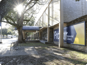 Exterior view of Frazar Memorial Library with sunlight and surrounding trees