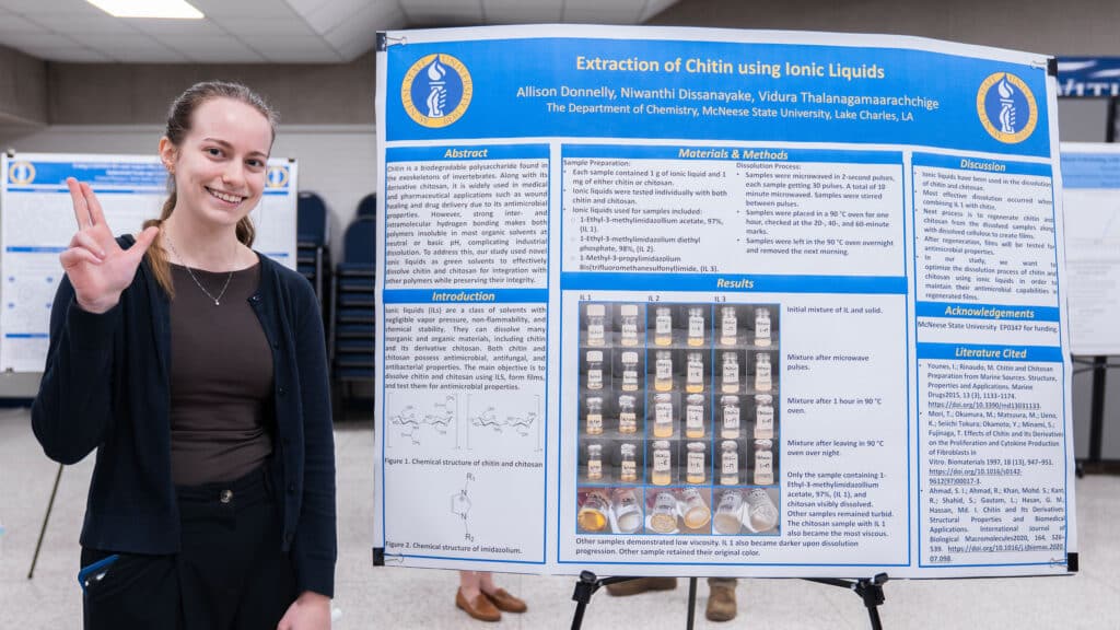 Allison Donnelly stands next to the poster that displays her research.