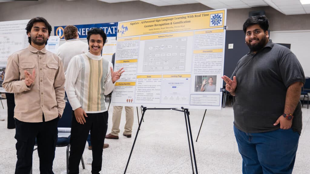 Three McNeese Computer Science students stand with their research poster that explains their program to teach sign language.