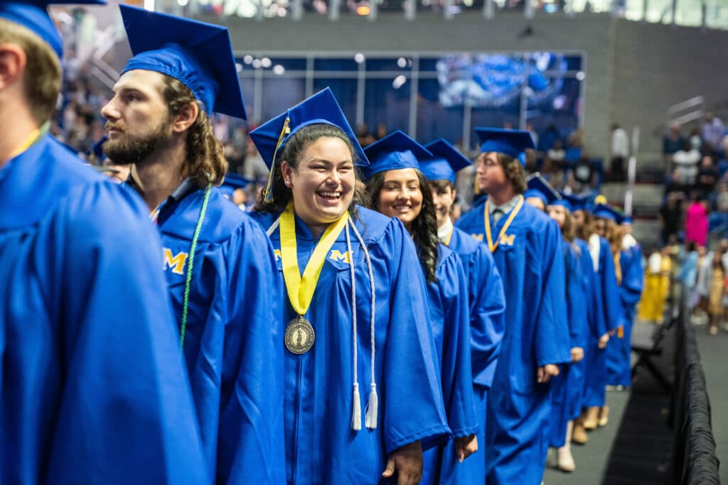 McNeese State University commencement ceremony. A line of students dress in blue cap and gowns for the ceremony.