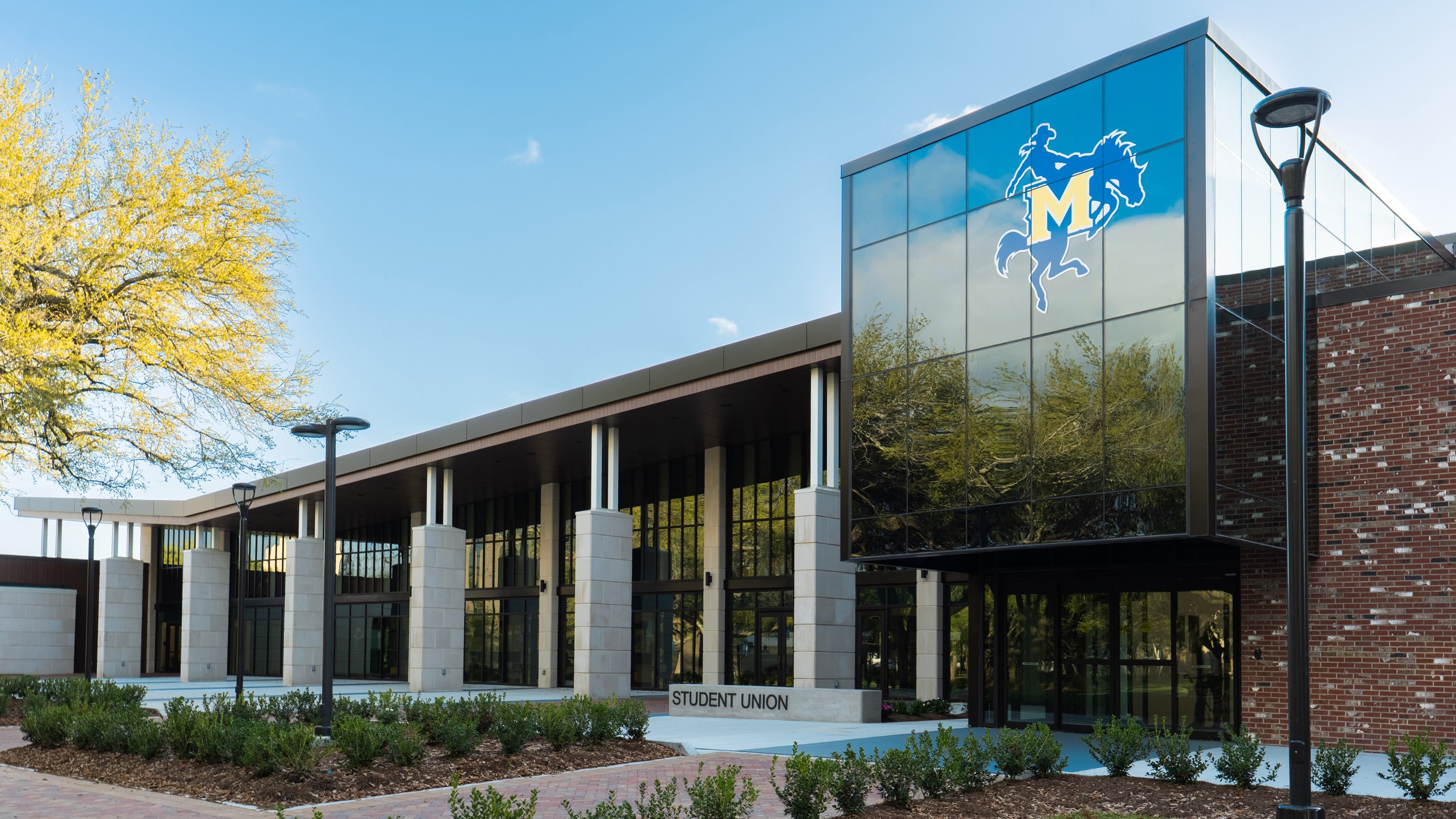 Exterior of a building with large glass window and the McNeese State University logo.