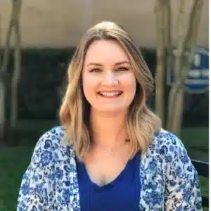 Smiling woman outdoors wearing a blue floral cardigan